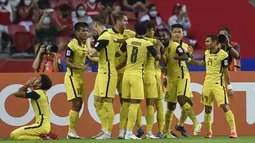 Penyerang Timnas Malaysia, Kogileswaran Raj  (ketiga kanan) berselebrasi dengan rekan setimnya setelah mencetak go ke gawang timnas Indonesia pada laga Grup B Piala AFF 2020 di Stadion Nasional Singapura, Minggu (19/12/2021). timnas Indonesia menaklukkan Malaysia 4-1. (AFP/Roslan Rahman)