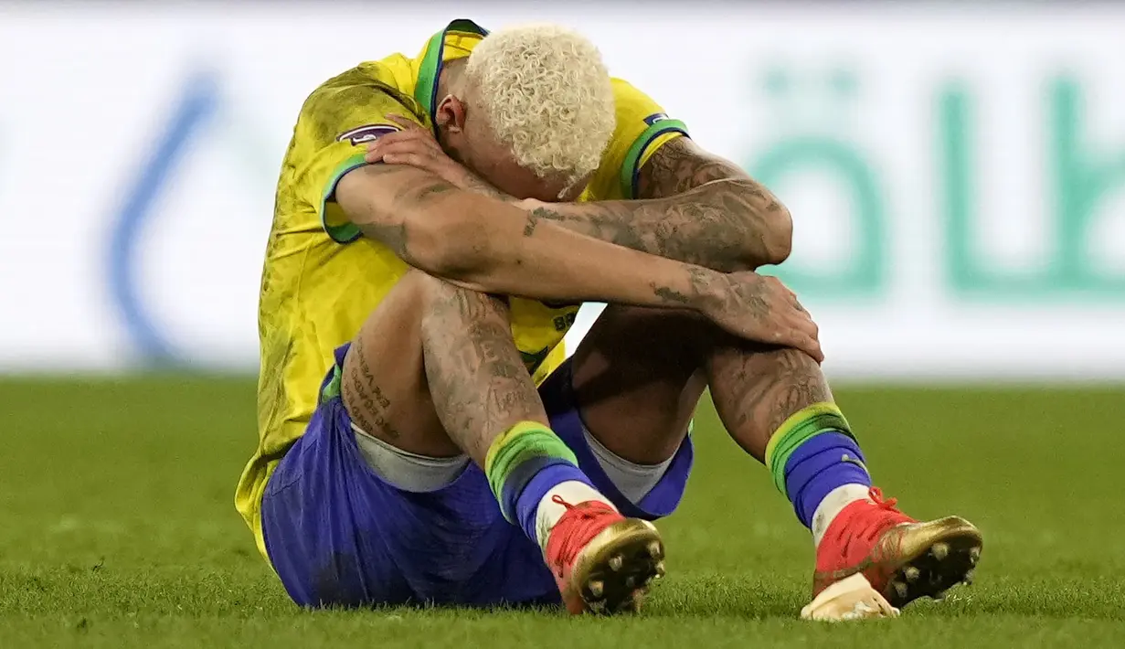 Pemain Brasil, Neymar tertunduk lesu setelah tim mereka kalah dari Kroasia saat laga perempat final Piala Dunia Qatar 2022 yang berlangsung di Education City Stadium, Al-Rayyan, Jumat (09/12/2022) waktu setempat. Brasil kalah 2-4 dari Kroasia saat babak adu penalti. (AFP/Anne-Christine Poujoulat)