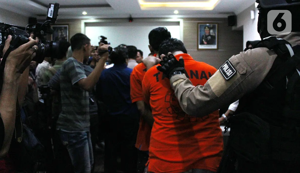 Polisi menggiring pelaku kasus prostitusi online di Apartemen Kalibata City saat konferensi pers di Polres Metro Jakarta Selatan, Rabu (29/1/2020). Polisi masih mendalami siapa saja pelanggan prostitusi online tersebut. (merdeka.com/Magang/Muhammad Fayyadh)