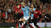 Striker Manchester City, Sergio Aguero (tengah), berduel dengan pemain Manchester United, Victor Lindelof (kiri) dan Fred pada laga di Old Trafford, 24 April 2019. (AFP/Oli Scarff)