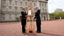 Senior footman Olivia Smith dan footman Heather McDonald saat memajang pengumuman kelahiran bayi baru kerajaan di halaman depan Istana Buckingham, London, Inggris, Senin (23/4). Kate Middleton melahirkan anak ketiganya. (Pool Photo via AP)