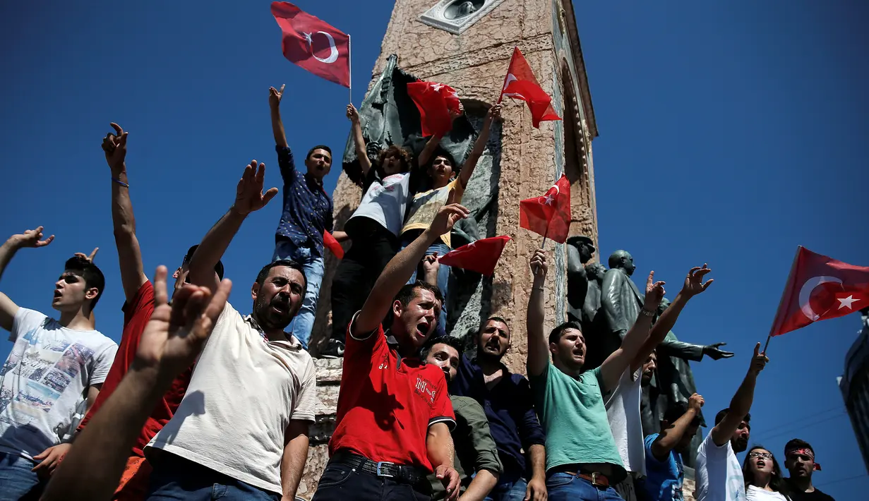 Pendukung Presiden Turki, Tayyip Erdogan meneriakkan slogan saat berdiri di sekitar Monumen Republik, pusat kota Istanbul, Sabtu (16/7). Ratusan warga turun ke jalan untuk merayakan kegagalan kudeta militer di Turki. (REUTERS/Alkis Konstantinidis)