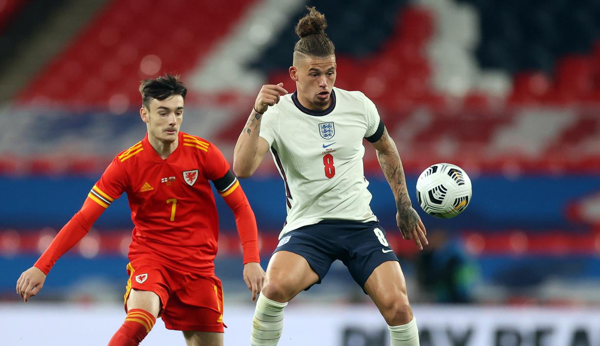 Gelandang Inggris, Kalvin Phillips, berebut bola dengan gelandang Wales, Dylan Levitt, pada laga persahabatan di Stadion Wembley, Jumat (9/10/2020) dini hari WIB. Inggris menang 3-0 atas Wales. (AFP/Carl Recine/pool)