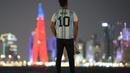 Seorang fans berdiri mengenakan kostum Argentina bertuliskan nama Messi di corniche Doha, di Doha, Qatar, Senin, 12 Desember 2022. Argentina akan menghadapi Kroasia dalam pertandingan semifinal Piala Dunia 2022 di Stadion Lusail Iconic Qatar, Rabu (14/12/2022) mulai pukul 02.00 WIB. (AP Photo/Andre Penner)