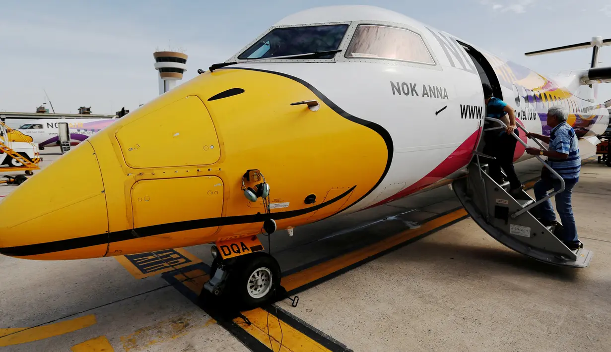 Penumpang menaiki pesawat Nok Air yang bergambar seperti bebek, di Bandara Don Muang, Bangkok, 11 Juni 2016. Nok Air adalah maskapai penerbangan bertarif murah yang berpusat di Bangkok, Thailand. (REUTERS/Jorge Silva)