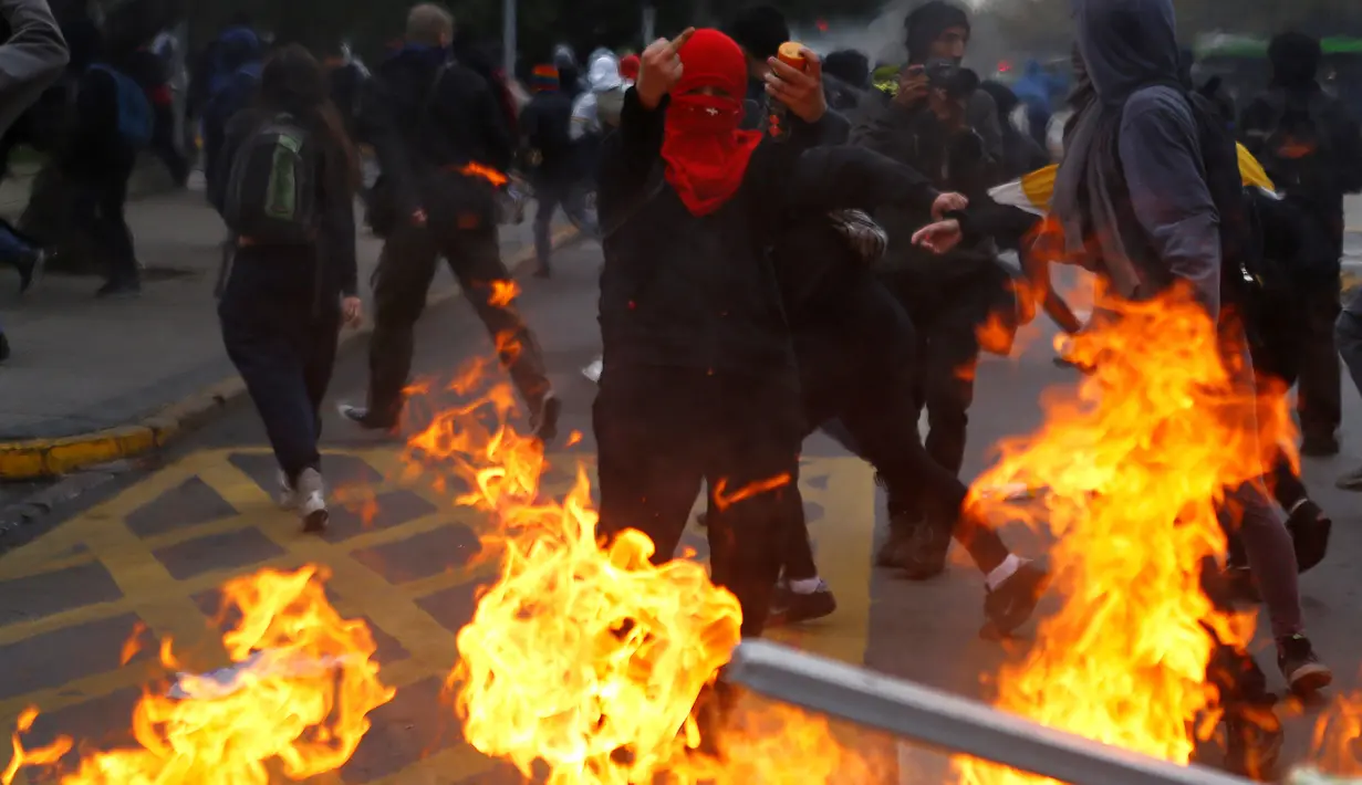 Sejumlah mahasiwa chili membakar fasilitas umum saat bentrok dengan polisi anti huru hara menuntut perubahan sistem pendidikan di Santiago, Chili, 11 Mei 2016. (REUTERS / Ivan Alvarado)