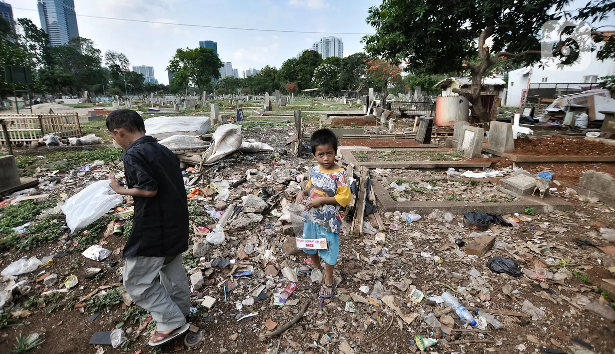 Anak-anak bermain di makam yang tertutup sampah di TPU Menteng Pulo 2, Jakarta, Senin (9/12/2019). Minimnya kesadaran warga setempat ditambah tidak adanya fasilitas TPA dan perawatan pengelola TPU menyebabkan kondisi kompleks makam memprihatinkan akibat dipenuhi sampah.(merdeka.com/Iqbal S. Nugroho)