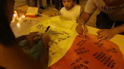 Sejumlah warga dari etnis Tiong Hoa berkumpul juga berkumpul menuliskan sebuah harapan di atas Koangming atau lentera langit (REUTERS / Edgar Su)