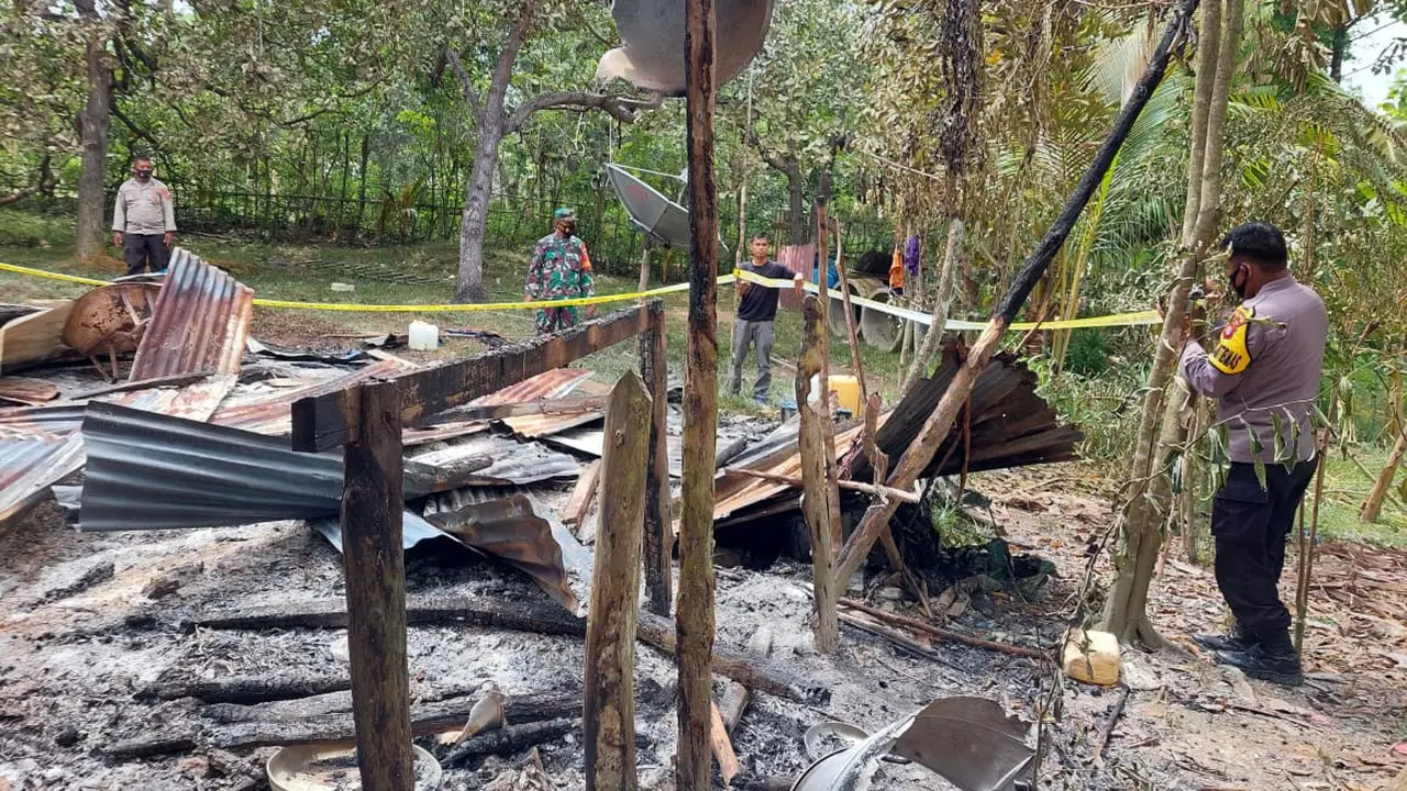 Polisi mengecek lokasi rumah sepasang suami istri di Konawe selatan usai dibakar massa karena sang istri dituduh memiliki ilmu hitam Parakang.(Liputan6.com/Dok Polsek Moramo Utara)