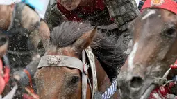 Ekspresi peserta saat mamacu kudanya dalam balap Armor Horse Racing di festival Soma Nomaoi di Minamisoma (30/7). Balapan ini diikuti oleh 12 penunggang kuda dengan jarak lomba 1.000 meter. (Jun Hirata/Kyodo News via AP)