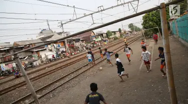 Suasana di pinggir rel kereta api di kawasan Kemayoran, Jakarta, Senin (24/7). Minimnya lahan bermain menyebabkan anak-anak terpaksa bermain di lokasi tersebut, meskipun berbahaya bagi keselamatan. (Liputan6.com/Immanuel Antonius)