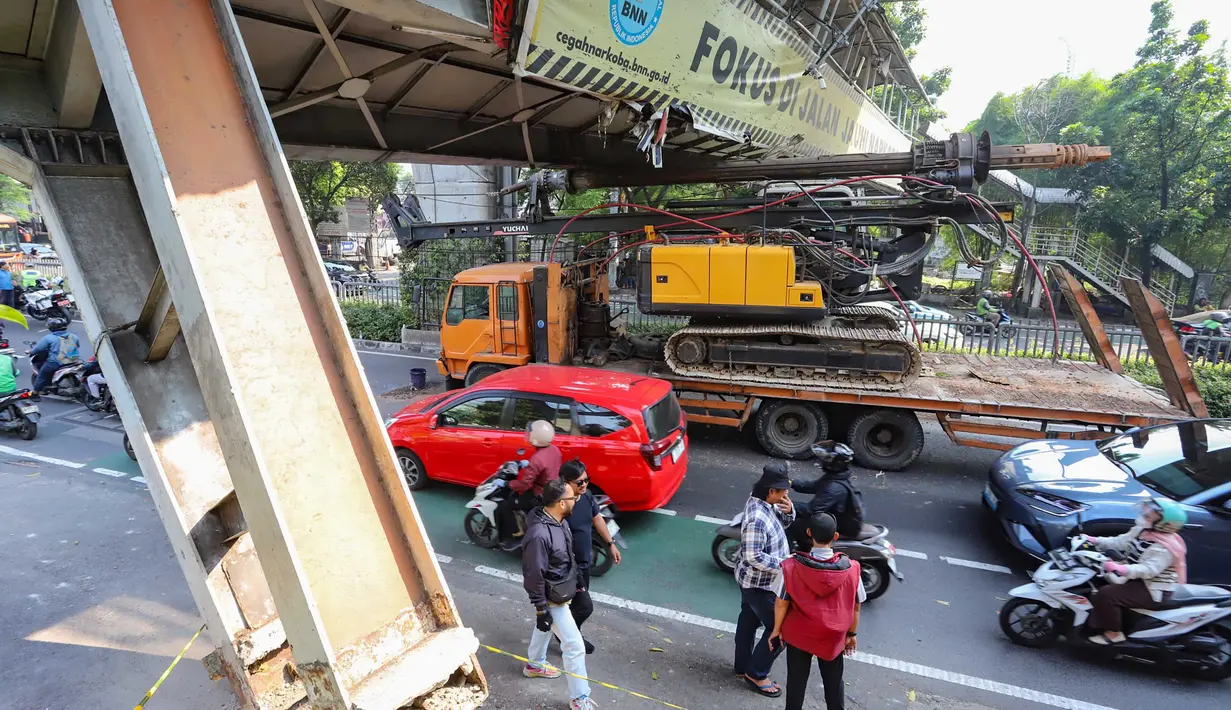 Sebuah truk  truk towing pengangkut alat berat (crane)  tersangkut dan merusak  jembatan penyeberangan orang (JPO) di Jalan Raya Kapten Tendean, Jakarta, Selasa (14/07/2026).
