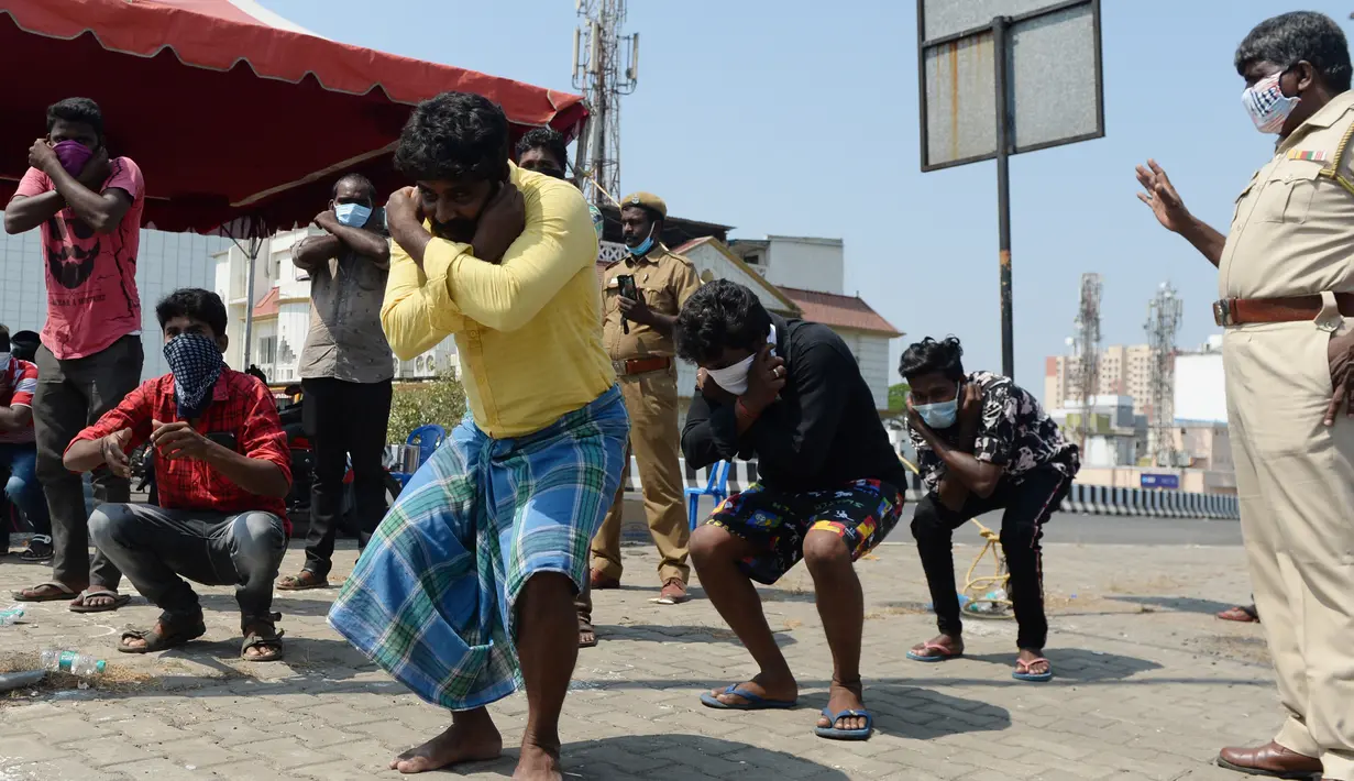 Orang-orang dipaksa untuk melepas alas kaki sebagai hukuman karena karena keluar rumah selama pemberlakukan penguncian wilayah (lockdown) di Chennai, Rabu (1/4/2020). Pemerintah India menerapkan kebijakan karantina wilayah atau lockdown dalam memerangi Virus Corona COVID-19. (Arun SANKAR / AFP)