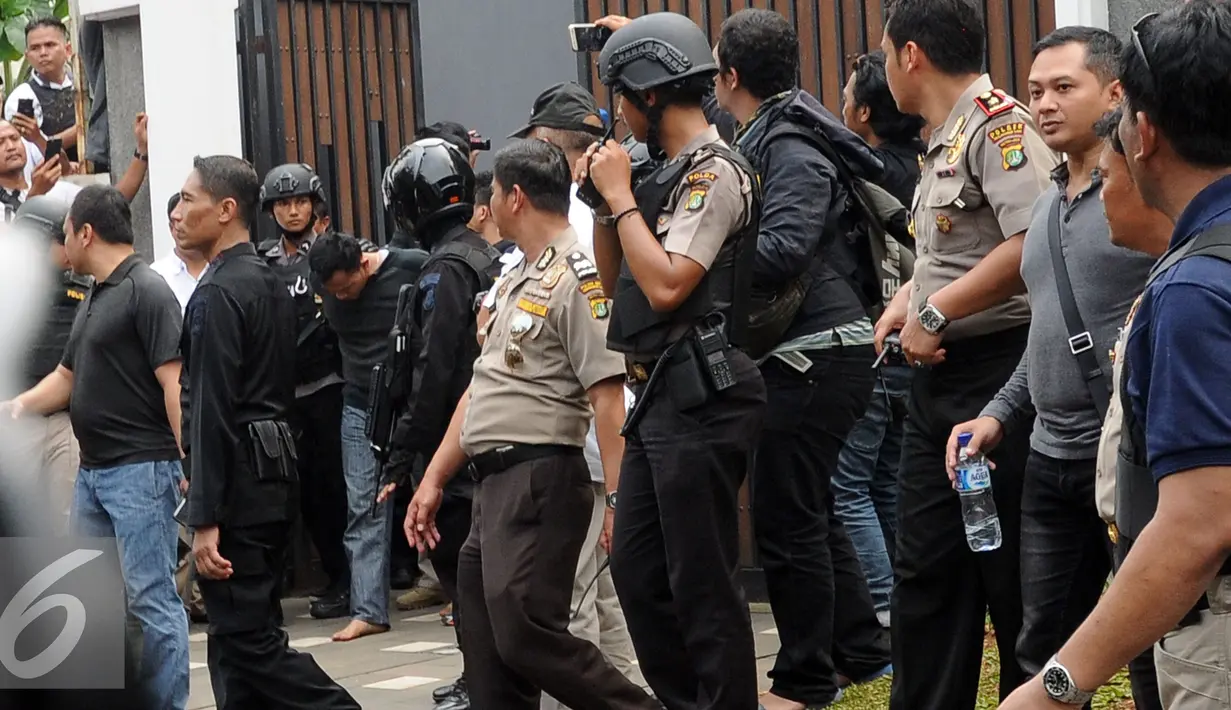 Petugas kepolisian mengamankan salah satu tersangka perampokan disertai penyanderaan di Kawasan Pondok Indah, Jakarta, Minggu (3/9). Dua tersangka pelaku perampokan disertai penyanderaan dilumpuhkan polisi. (Liputan6.com/Helmi Fithriansyah)