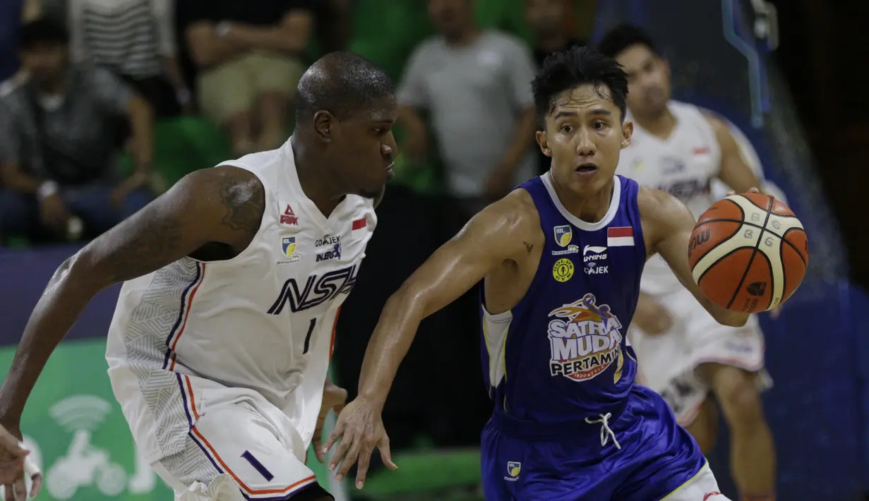 Pebasket Satria Muda, Herdianus, berusaha melewati pebasket NSH Jakarta, Anthony Simpson, pada laga semi final IBL 2019 di GMSB Kuningan, Jakarta, Minggu (10/3). Satria Muda menang 72-48 atas NSH Jakarta. (Bola.com/M Iqbal Ichsan)