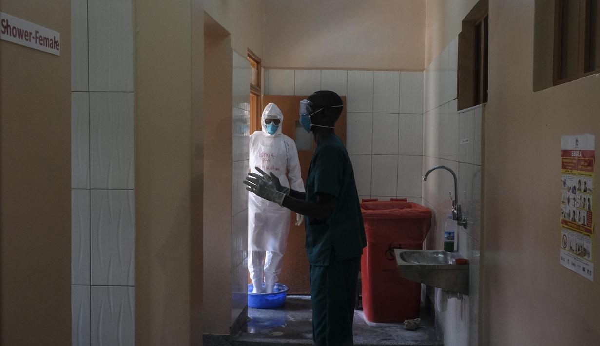 Dokter mendisinfeksi diri mereka sendiri setelah mengunjungi pasien yang kontak dengan korban Ebola, di bagian isolasi Rumah Sakit Rujukan Regional Entebbe di Entebbe, Uganda Kamis, 20 Oktober 2022. Pejabat WHO mengatakan pada Kamis (20/10), Wabah Ebola di Uganda berkembang pesat dalam sebulan yang membuat situasi yang sulit bagi petugas kesehatan di lapangan. (AP Photo/Hajarah Nalwadda)