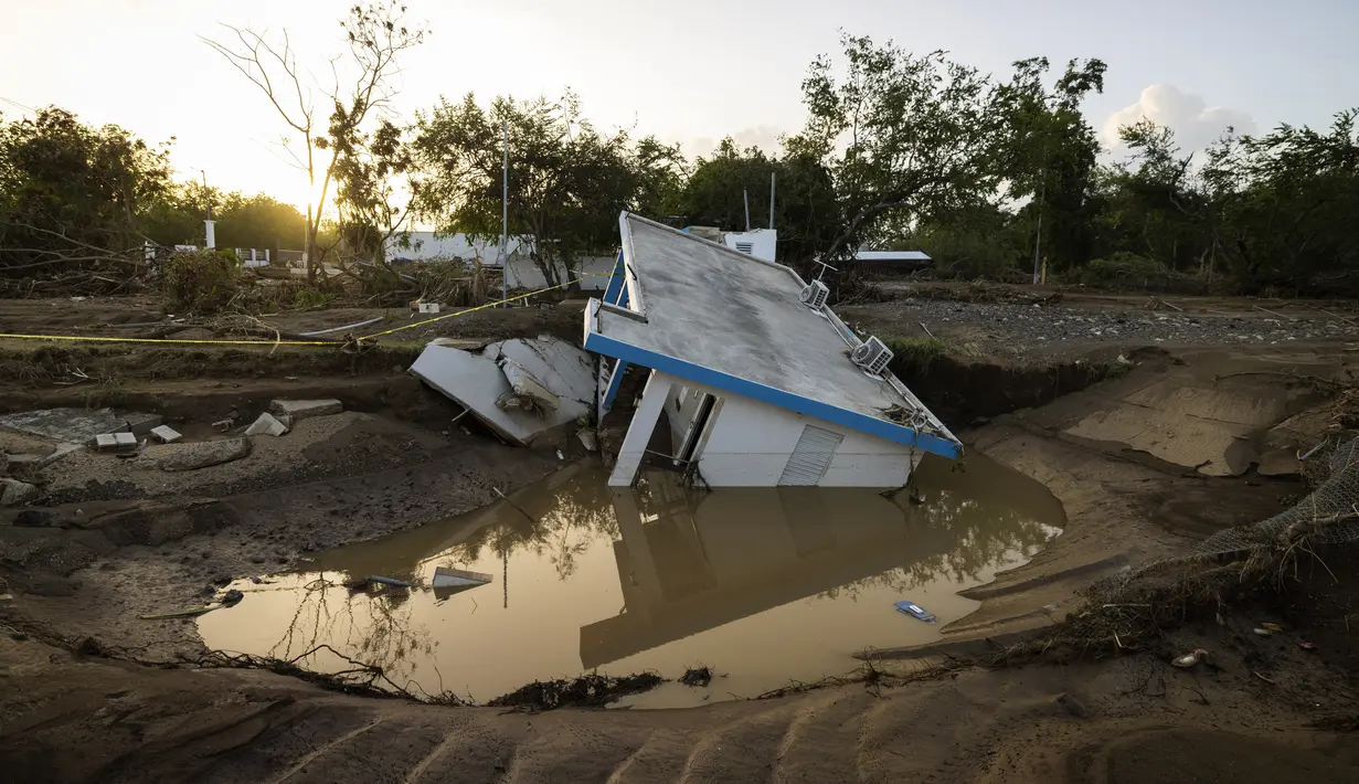 Pemandangan sebuah rumah yang hanyut oleh Badai Fiona di Villa Esperanza di Salinas, Puerto Rico, Rabu, 21 September 2022. Menurut para pejabat di Puerto Rico, badai tropis fional juga menyebabkan sekitar 196.000 orang kehilangan air minum akibat pemadaman listrik dan banjir sungai. (AP Photo/Alejandro Granadillo)