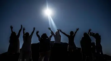 Para jemaah mengangkat tangan mereka ke arah matahari di piramida Teotihuacan di kota San Juan Teotihuacan, Negara Bagian Meksiko, saat perayaan equinoks musim semi pada 21 Maret 2024. (CARL DE SOUZA/AFP)