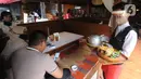 Pramusaji menggunakan pelindung wajah, masker dan sarung tangan di Rumah Makan Bumi Aki, Pajajaran, Kota Bogor, Minggu  (31/5/2020). Sejumlah restoran dan rumah makan di Bogor mulai membuka layanan makan di tempat dengan protokol kesehatan ketat guna mengatasi COVID-19. (merdeka.com/Arie Basuki)
