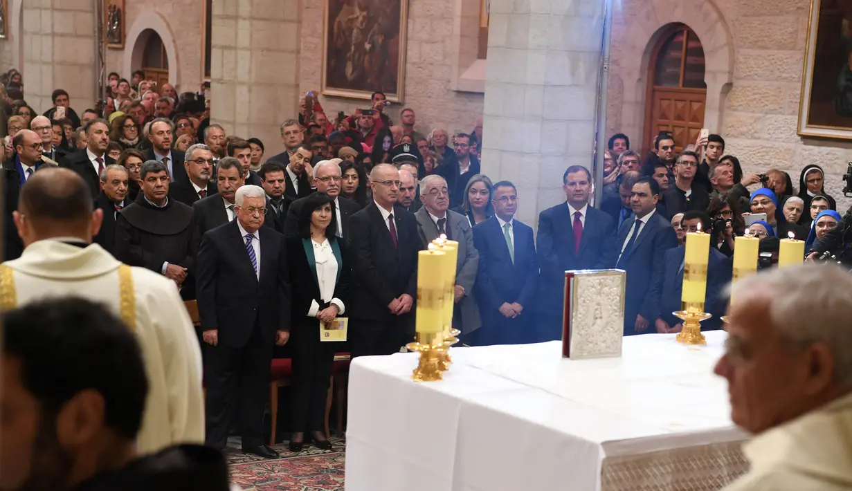 Presiden Palestina Mahmoud Abbas saat menghadiri misa Natal di Gereja Santa Katarina yang terhubung ke Gereja Nativity, di kota Bethlehem di Tepi Barat, (25/12). (AFP Photo/Musa Shaer Poll)