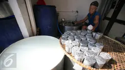 Pekerja mencuci cetakan  kue keranjang usai digunakan mencetak di industri kue keranjang rumahan Yogyakarta, (22/1). Kue keranjang disini dijual dengan harga Rp. 33.000 per kilogram. (Boy Harjanto)