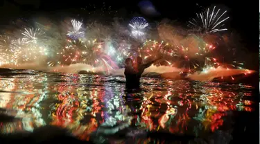 Pasangan saat menikmati kembang api yang meledak menghiasi langit di pantai Copacabana saat perayaan Tahun Baru 2016 di Rio de Janeiro, Brasil, (1/1/2016). (REUTERS/Ricardo Moraes)