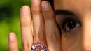 Seorang model mengenakan berlian "The Pink Star" sebelum dilelang oleh Sotheby di London, 20 Maret 2017. Pada 2013, The Pink Star pernah terjual seharga US$83 juta di Jenewa, dan menjadi berlian termahal yang pernah dilelang (AP Photo/Kirsty Wigglesworth)