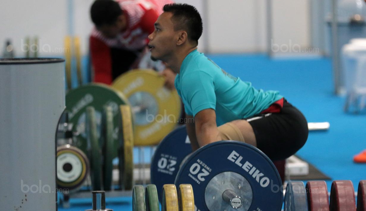 Persiapan Eko Yuli Irawan saat berlatih sebelum turun pada kelas 62 kg di Hall A Arena PRJ, Jakarta, Rabu (11/2/2018). Eko berhasil menyabet medali emas. (Bola.com/Nicklas Hanoatubun)