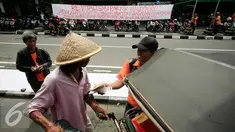 Juru parkir melakukan aksi dengan membagikan nasi bungkus di Jalan Malioboro,Yogyakarta, Jumat (11/3). Dalam aksinya mereka meminta dukungan kepada pengguna jalan yang melintas dan menuntut kejelasan relokasi yang bernurani. (Liputan6.com/Boy Harjanto)