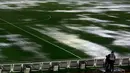 Seorang kamerawan saat berada dipinggir lapangan tergenang air akibat hujan lebat di stadion Monumental, Argentina, Jumat (13/11/2015). Karena cuaca buruk Pertandingan antara Argentina dan Brasil mengalami pengunduran. (REUTERS/Marcos Brindicci)