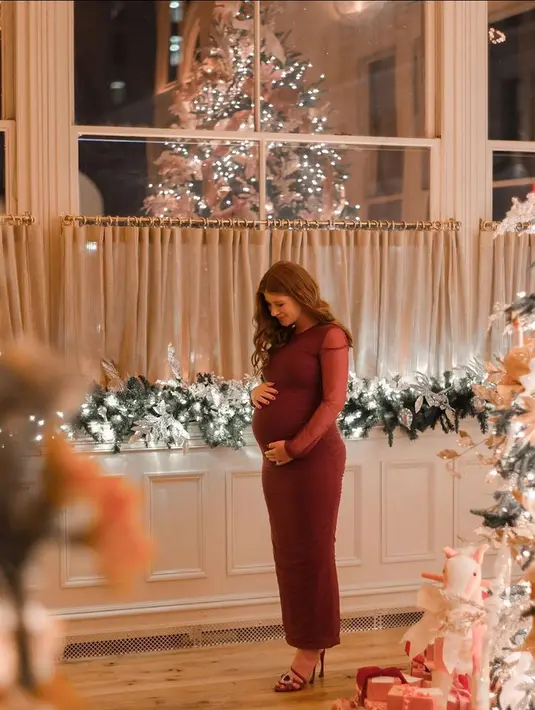 Ia tampil memukau dalam balutan gaun bernuansa maroon dalam pesta baby showernya. [Foto: @jenniferkgates]