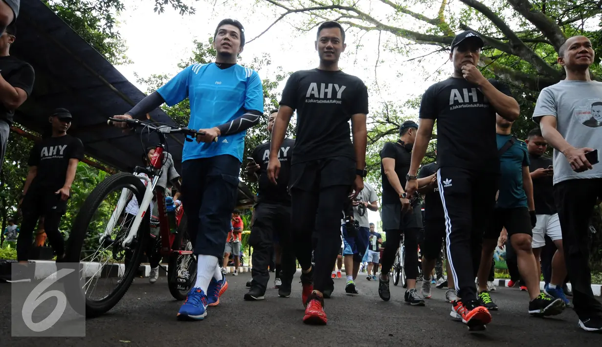 Bakal calon gubernur DKI Jakarta, Agus Harimurti Yudhoyono (kedua kiri) berjalan bersama warga jelang berolahraga di Kebun Binatang Ragunan Jakarta, Minggu (9/10). Selain olahraga, AHY juga melakukan  sosialisasi. (Liputan6.com/Helmi Fithriansyah)