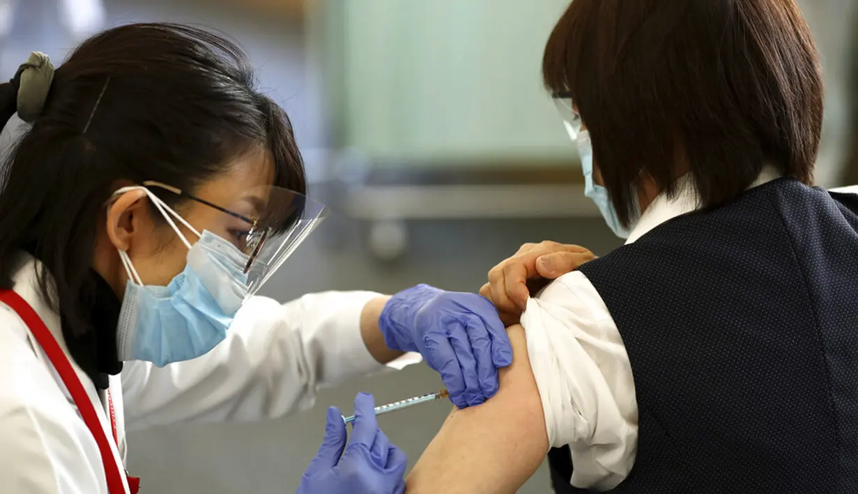 Seorang pekerja medis menerima dosis vaksin virus corona COVID-19 di Tokyo Medical Center, Tokyo, Jepang, Rabu (17/2/2021). Jepang memulai kampanye vaksinasi COVID-19 dengan suntikan COVID-19 pertama diberikan kepada petugas kesehatan. (Behrouz Mehri/Pool Photo via AP)
