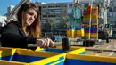 Seorang wanita menyusun LEGO yang akan dibuat menjadi menara di Lapangan Rabin di Tel Aviv, Israel, Rabu (27/12). Menara ini dibangun untuk menghormati penggemar LEGO berusia 8 tahun, Omer Sayag yang meninggal pada tahun 2014 silam. (AFP Photo/Jack Guez)