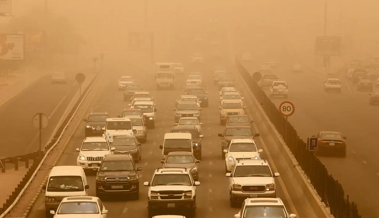 Kendaraan melintas di sepanjang jalan raya yang diselimuti debu tebal selama terjangan badai pasir di Kuwait City, Kuwait, pada 17 Juni 2021. Terjangan badai pasir ini membuat jarak pandang atau visibilitas di beberapa daerah turun hingga kurang dari 100 meter. (AFP/YasserAl-Zayyat)