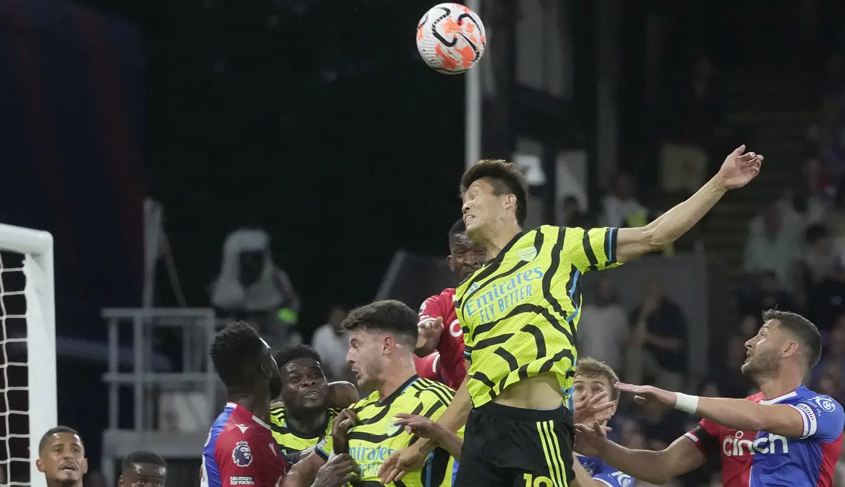 Bek Arsenal, Takehiro Tomiyasu (tengah) berusaha menghalau bola dari ancaman pemain Crystal Palace pada laga pekan kedua Liga Inggris 2023/2024 di Selhurst Park, London (21/8/2023). (AP Photo/Kin Cheung)