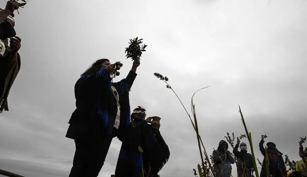 Masyarakat Adat Mapuche mengambil bagian dalam ritual selama gerhana matahari total di Carahue, La Araucania, Chile, Senin (14/12/2020). Gerhana matahari total terlihat dari Chile dan wilayah Patagonia utara Argentina. (AP Photo/Esteban Felix)