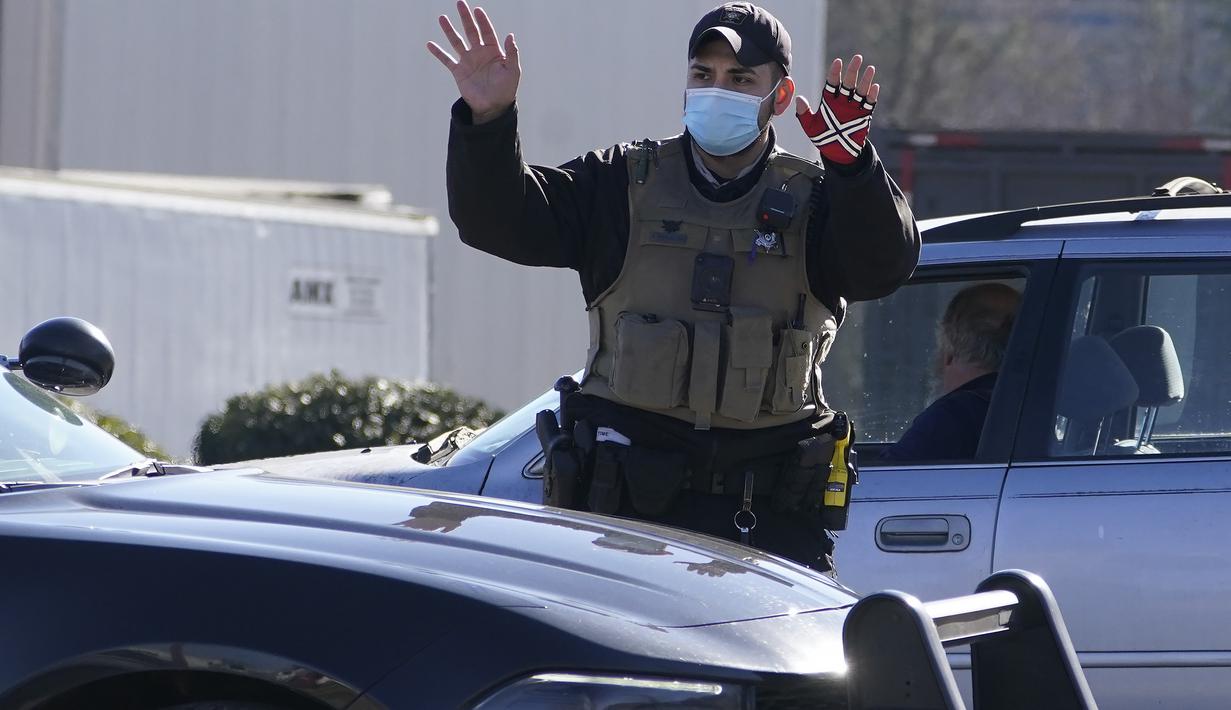 Seorang petugas polisi mengarahkan lalu lintas setelah kebocoran nitrogen cair yang menewaskan enam orang di Prime Pak Foods, sebuah pabrik unggas di Gainesville, Ga., Kamis (28/1/2021). (AP Photo/John Bazemore)