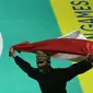 Pesilat Indonesia Sugianto membawa bendera merah putih usai meraih medali emas dalam babak final tunggal putra pencak silat seni Asian Games 2018 di Padepokan Pencak Silat Taman Mini Indonesia Indah (TMII), Jakarta, Rabu (29/8). (Merdeka.com/ Imam Buhori)