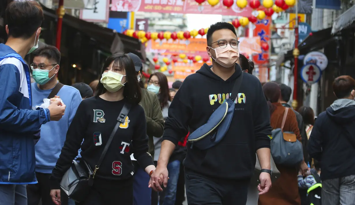 Pasangan memakai masker untuk mencegah penyebaran virus corona berjalan di pasar Dihua Street di Taipei, Taiwan, Rabu (10/2/2021).  Pasar Dihua Street di Taipei menjadi salah satu pasar terpopuler yang menjajakan perlengkapan Tahun Baru Imlek. (AP Photo/Chiang Ying-ying)