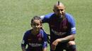 Pemain baru Barcelona, Arturo Vidal, bersama anaknya Alonso, saat perkenalan di Stadion Camp Nou, Senin, (7/8/2018). Barcelona merogoh kocek sebesar 19 juta euro untuk mengamankan jasa pria berkebangsaan Cile itu. (AP/Manu Fernandez)