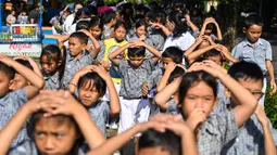 Ribuan siswa dan peserta didik mengikuti kegiatan simulasi evakuasi mandiri di kawasan Blang Padang dan Museum Tsunami, Rabu (9/10/2024). (CHAIDEER MAHYUDDIN/AFP)