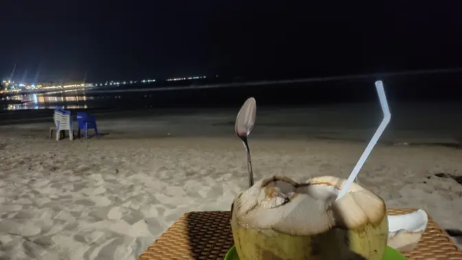 <p>Menikmati air kelapa muda di tepi Pantai Kuta di Pulau Dewata Bali ( / Nefri Inge)</p>