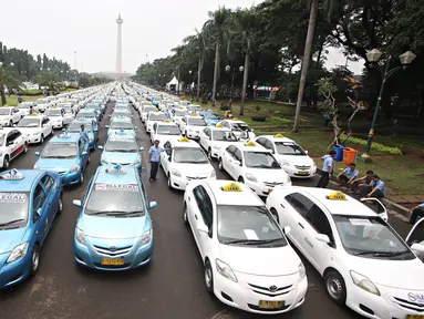Ratusan armada taksi parkir di sepanjang silang Monas, Jakarta, (14/3). Mereka merasa dirugikan dengan banyaknya tranportasi berplat hitam yang berbasis online tersebut. (Liputan6.com/Immanuel Antonius)