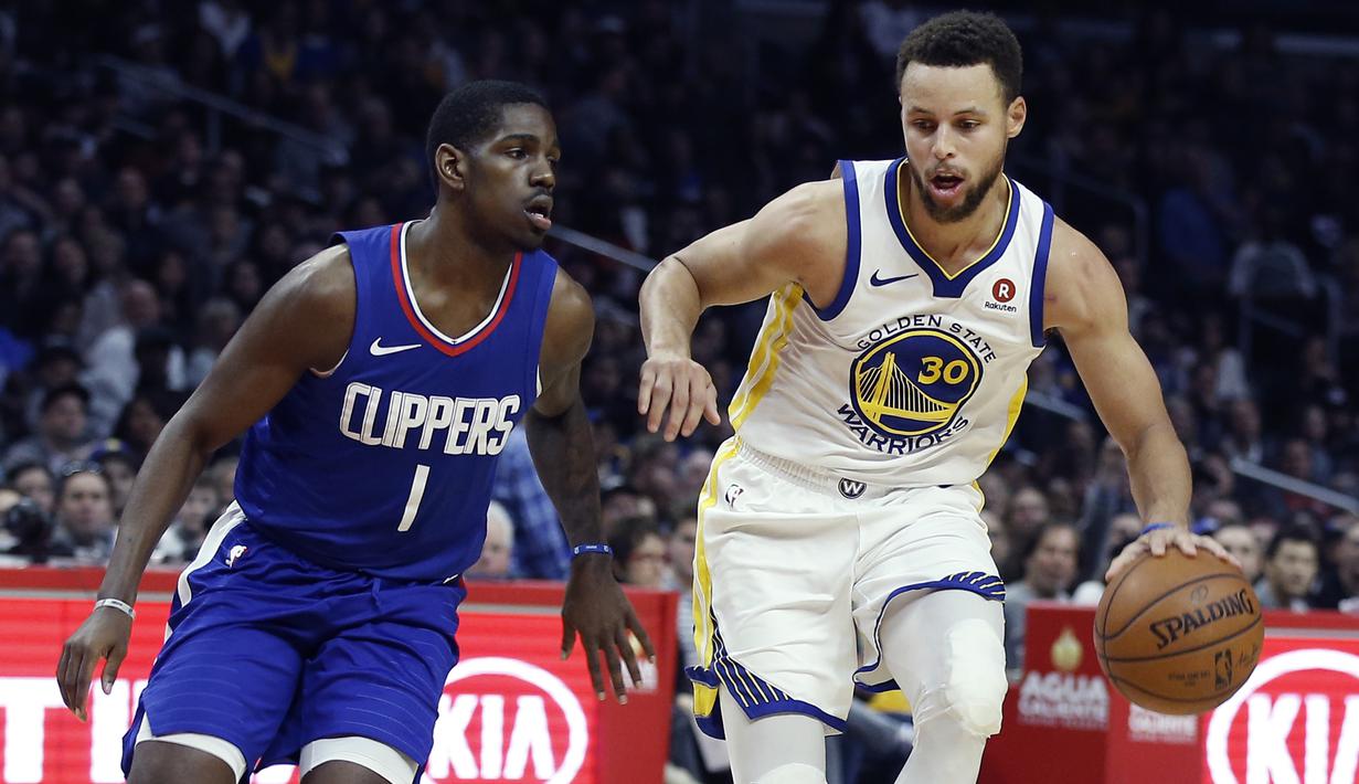 Aksi pemain Warriors, Stephen Curry (kanan) melewati adangan pemain Clippers, Jawun Evans pada laga NBA basketball game di Staples Center, Los Angeles, (6/1/2018). Warriors 121-105. (AP/Alex Gallardo)