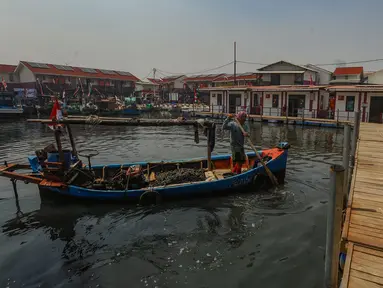 Nelayan membawa kerang hijau usai melaut ke rumahnya yang sudah direnovasi menjadi rumah apung  di Kampung Nelayan Muara Angke, Jakarta Utara, Rabu (14/8/2024). (merdeka.com/Arie Basuki)