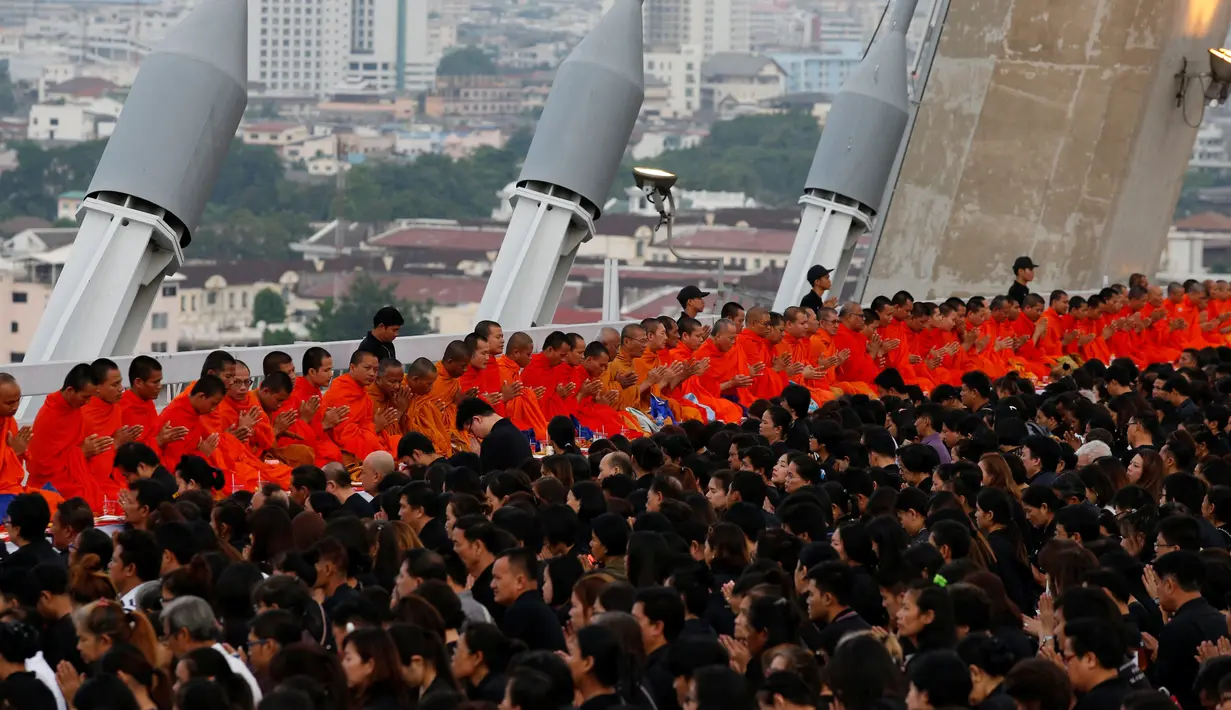 Biksu dan warga saat merayakan HUT terakhir almarhum Raja Thailand, Bhumibol Adulyadej di atas Jembatan Bhumibol, Bangkok, Thailand, Senin (5/12). Raja Thailand Bhumibol Adulyadej meninggal di RS Siriraj. (REUTERS/Jorge Silva)