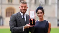 Mantan pesepak bola, Sir David Beckham (kiri) berfoto bersama dengan istrinya, Victoria Beckham sambil menunjukkan medali setelah dinobatkan gelar baru oleh raja Inggris, Charles III di Kastil Windsor, Berkshire, Inggris, Selasa (04/11/2025) waktu setempat. (AP Photo/Pool/Andrew Matthews)