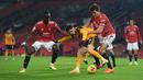 Gelandang Wolverhampton Wanderers, Pedro Neto (tengah) dikurung dua bek Manchester United, Eric Bailly (kiri) dan Harry Maguirre dalam laga lanjutan Liga Inggris 2020/21 pekan ke-16 di Old Trafford, Selasa (29/12/2020). Wolverhampton kalah 0-1 dari Manchester United. (AFP/Michael Regan/Pool)