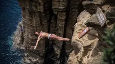 Peserta asal Bulgaria, Todor Spasov, melakukan lompatan setinggi 27 meter dari tebing Islet Franca do Campo dalam kompetisi Red Bull Cliff Diving World Series di Sao Miguel, Portugal, 7 Juli 2017. (Romina Amato/Red Bull Content Pool via AP Images)